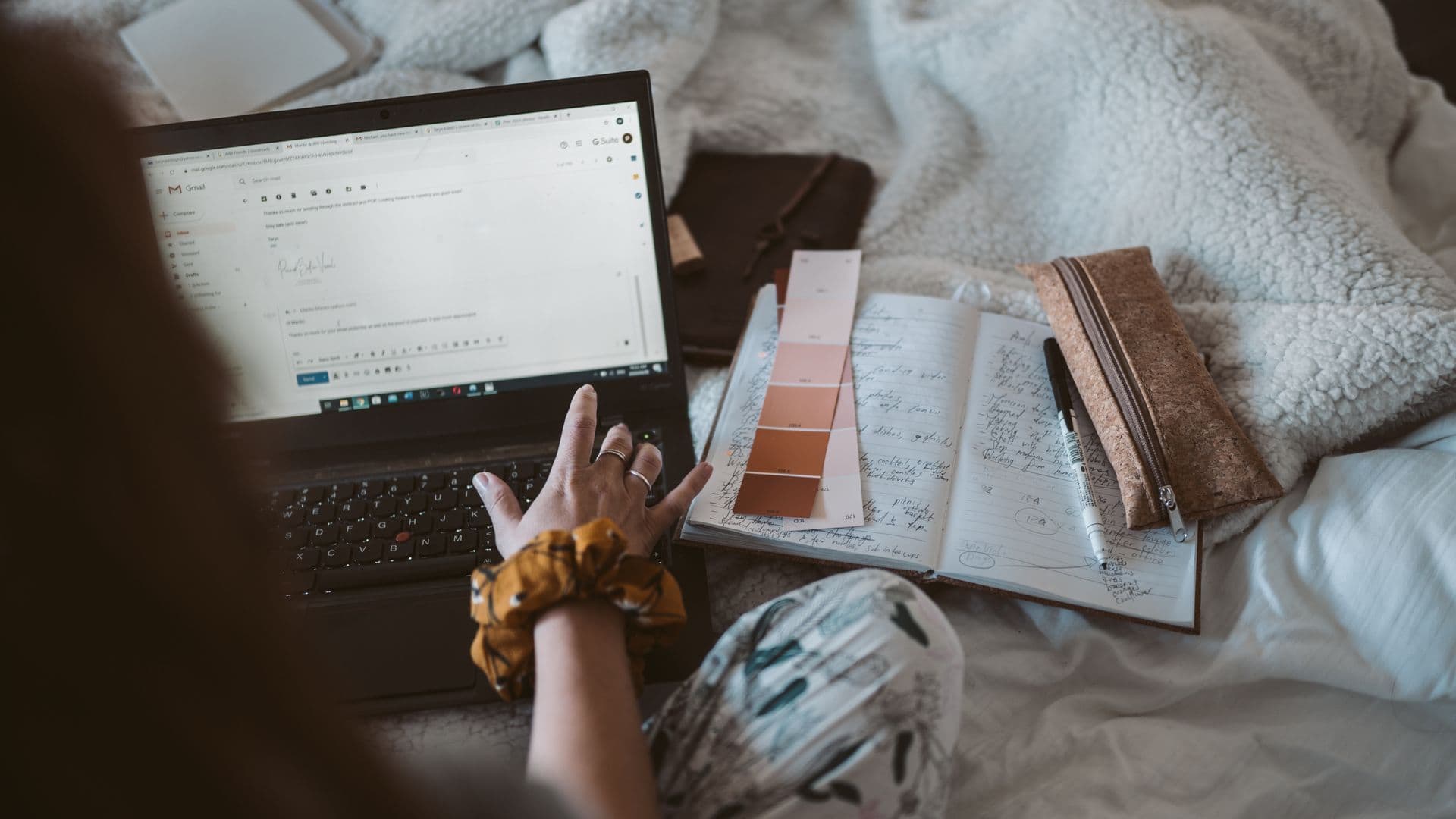 Woman working from home with a laptop and written records for tax time