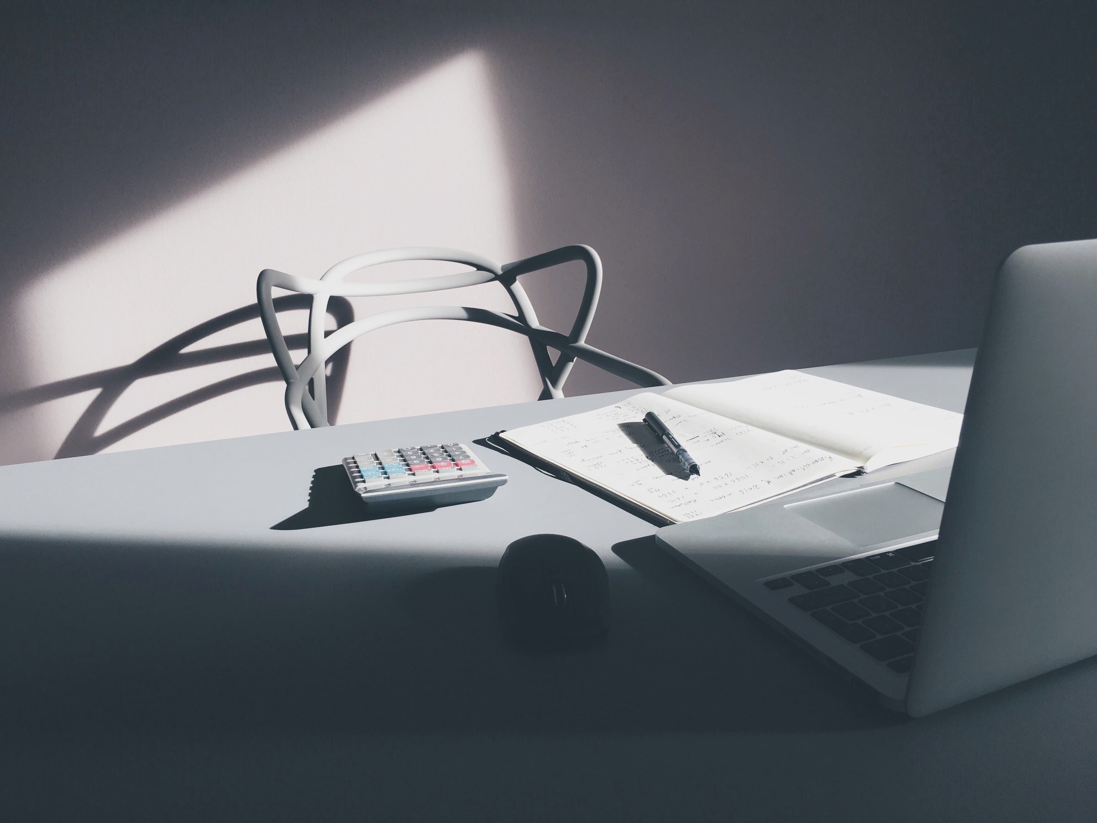 Laptop and calculator on a desk, representing an electricity bill comparison.