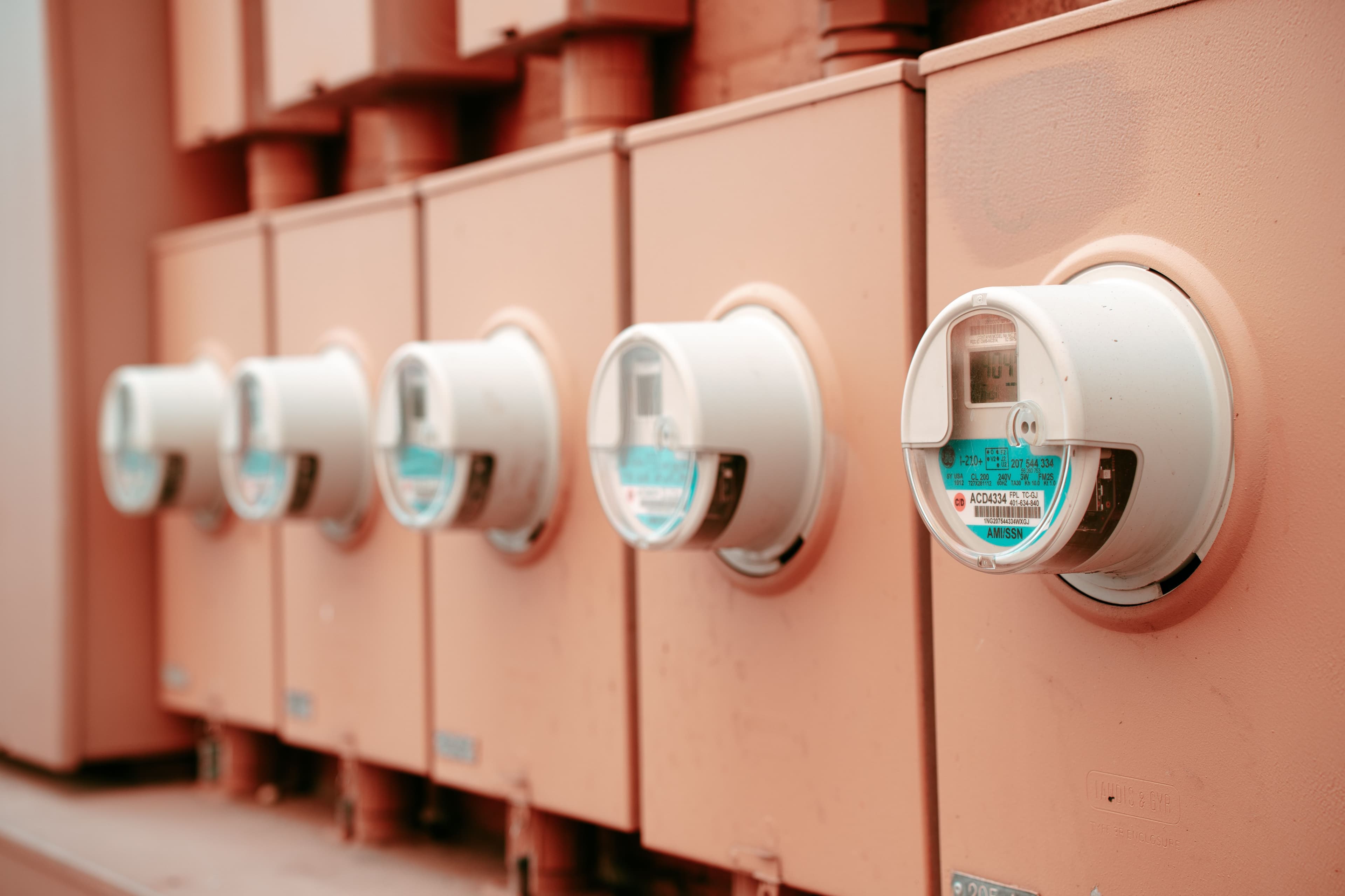 Row of electricity meters mounted outside a residential property.