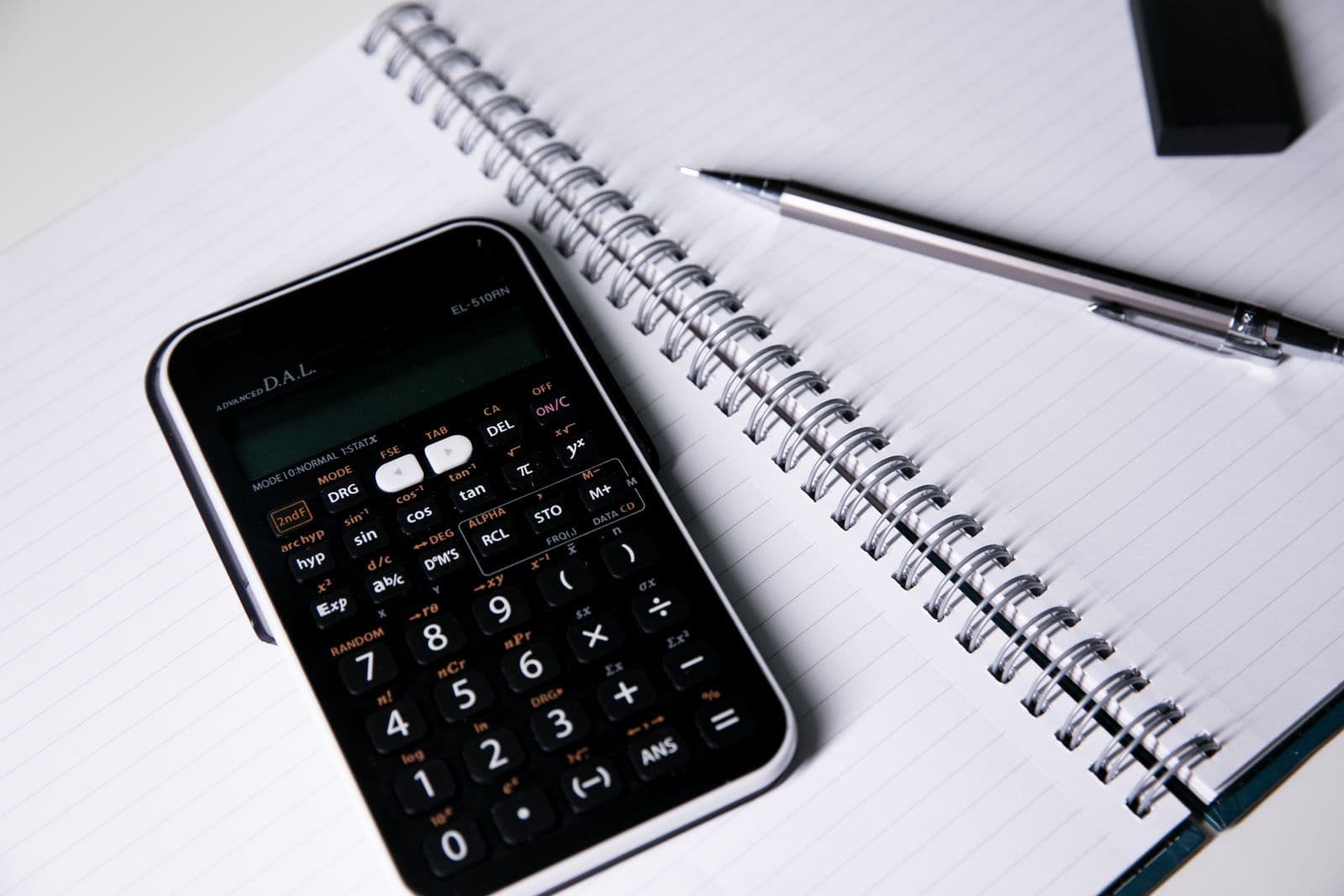 Calculator, notebook and pen on a desk
