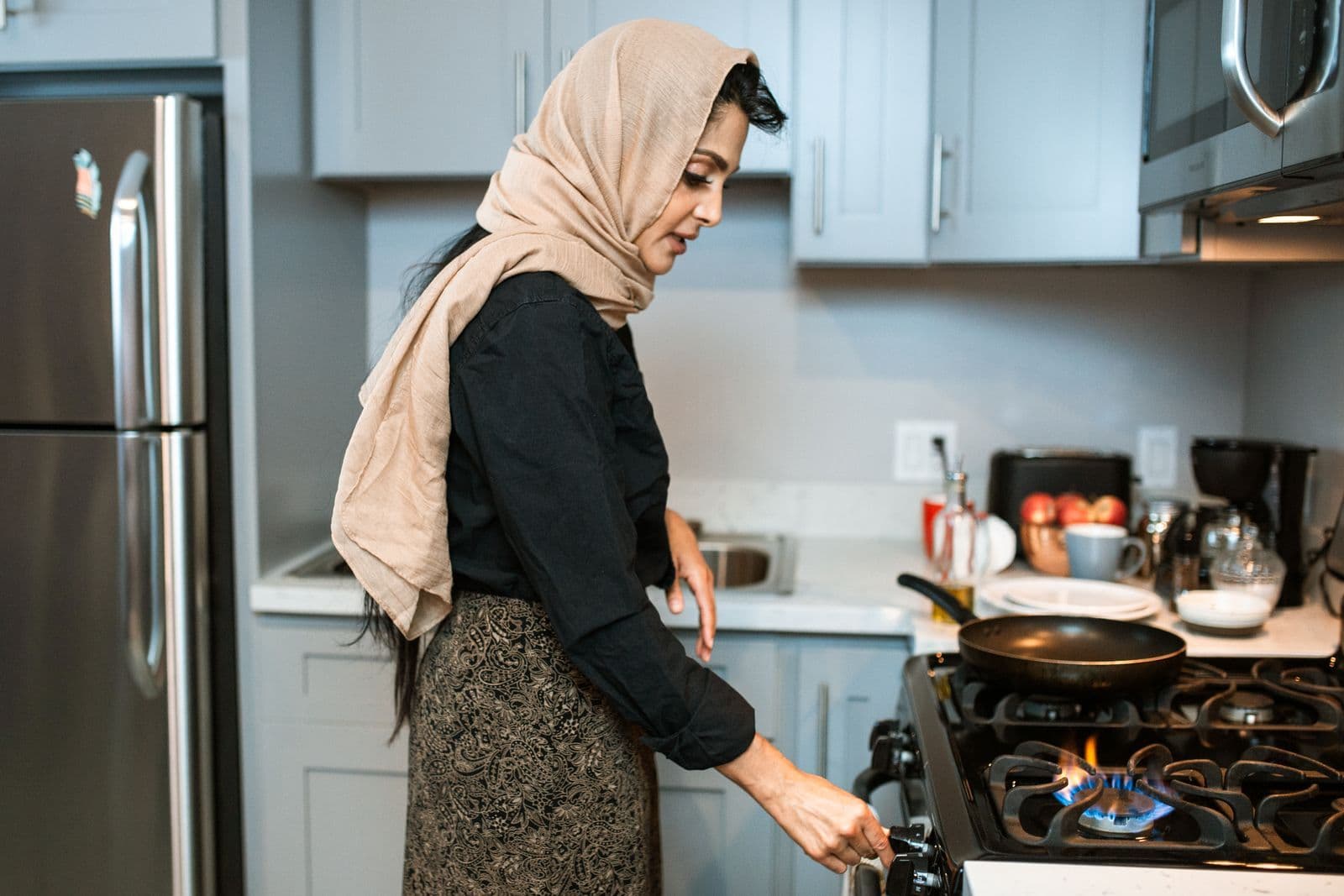 Woman using a gas stove in a home kitchen