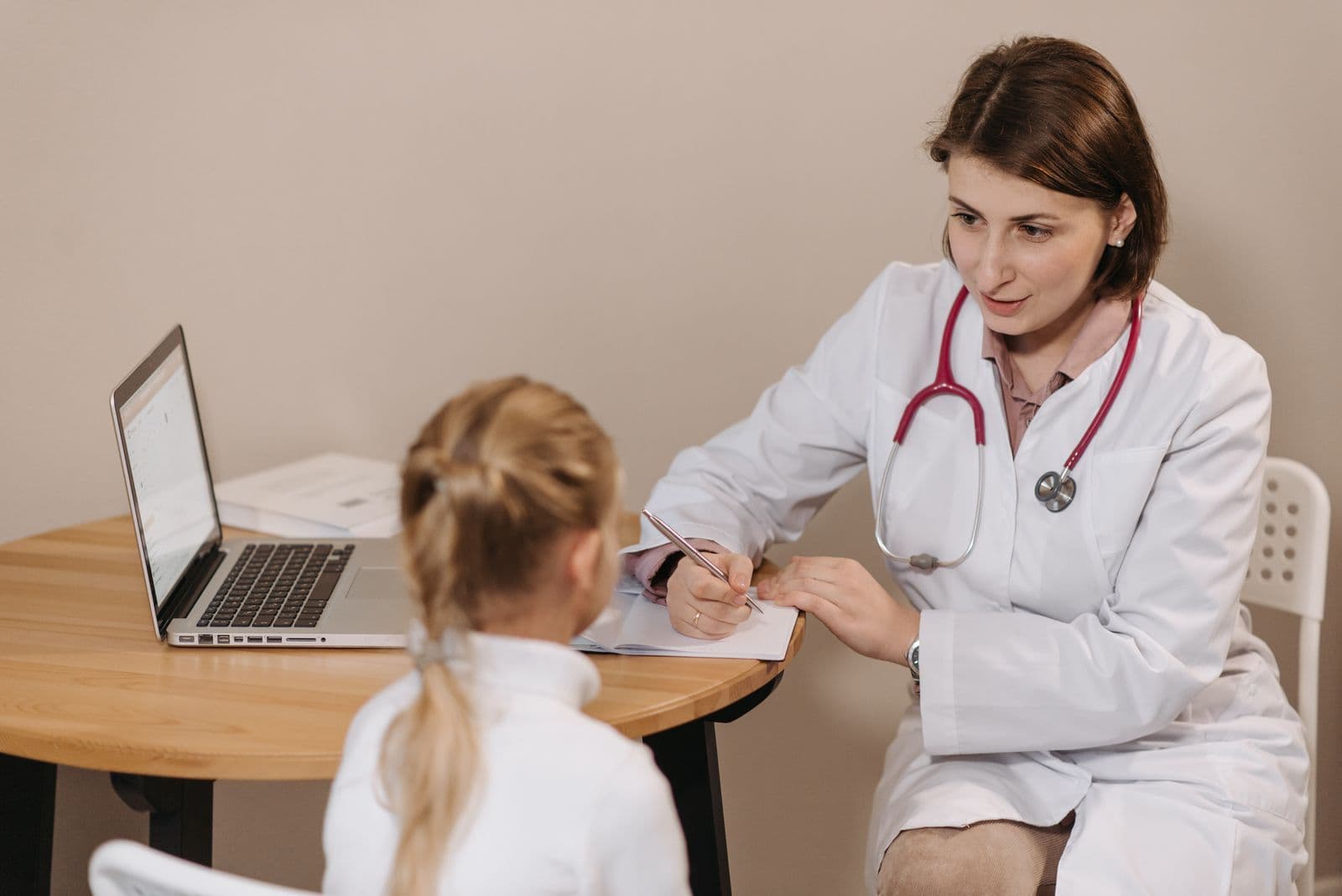 Healthcare professional speaking with a child during a consultation