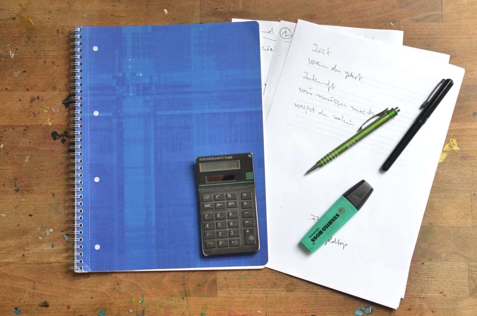 Calculator, notebook and pens arranged for comparing costs