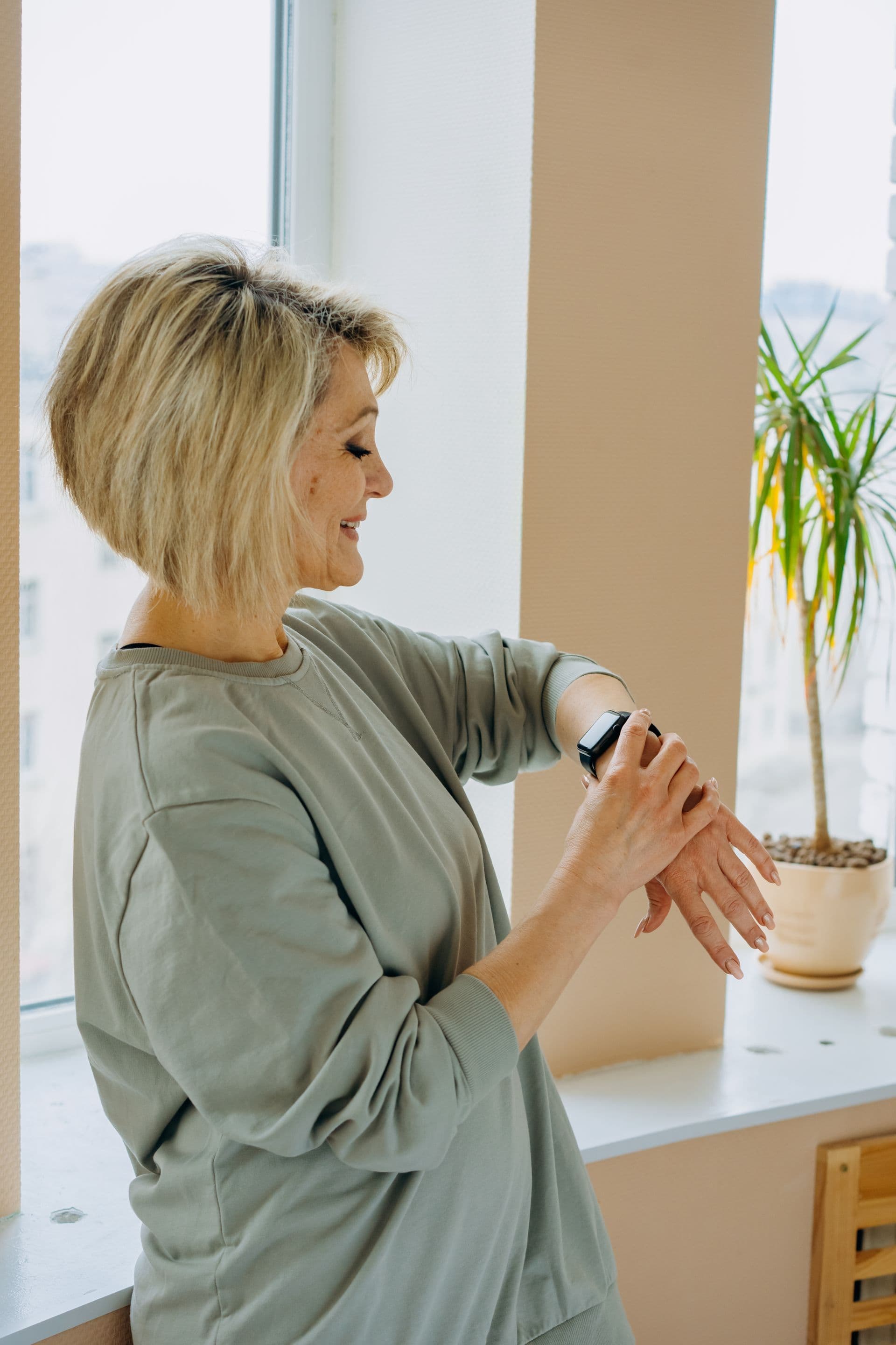 Older woman using a laptop at home while reviewing connectivity for a medical alarm