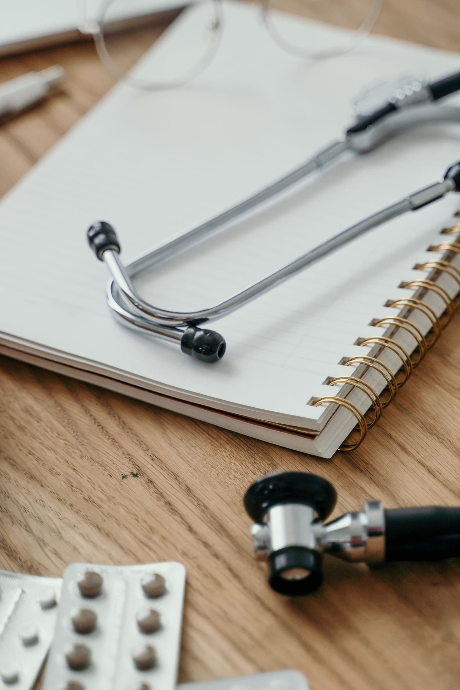 A stethoscope resting on a notebook on a desk