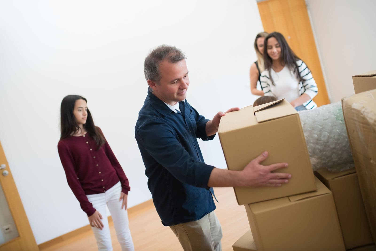 Family unpacking cardboard boxes in a new home