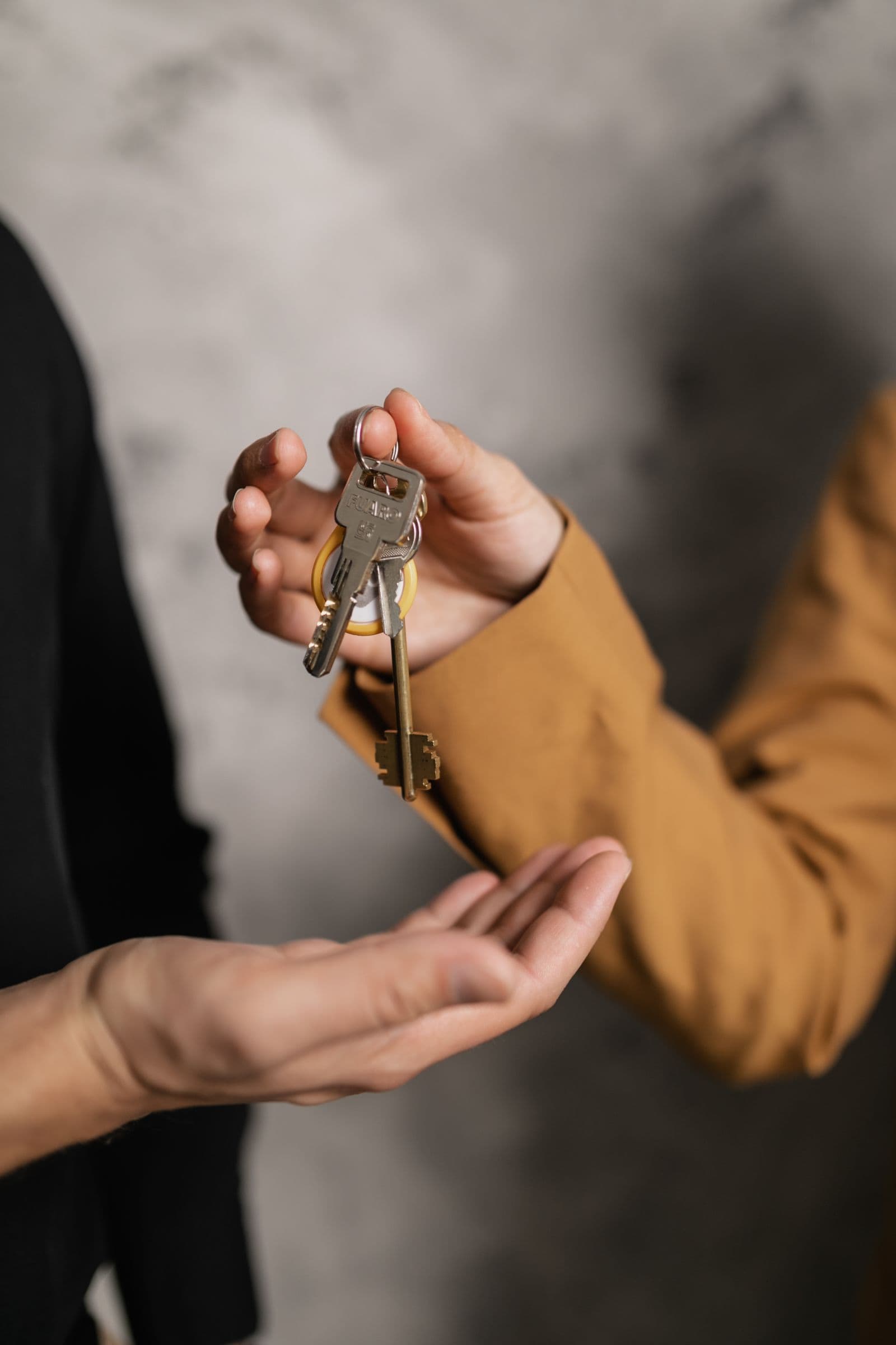Two adults handing over house keys