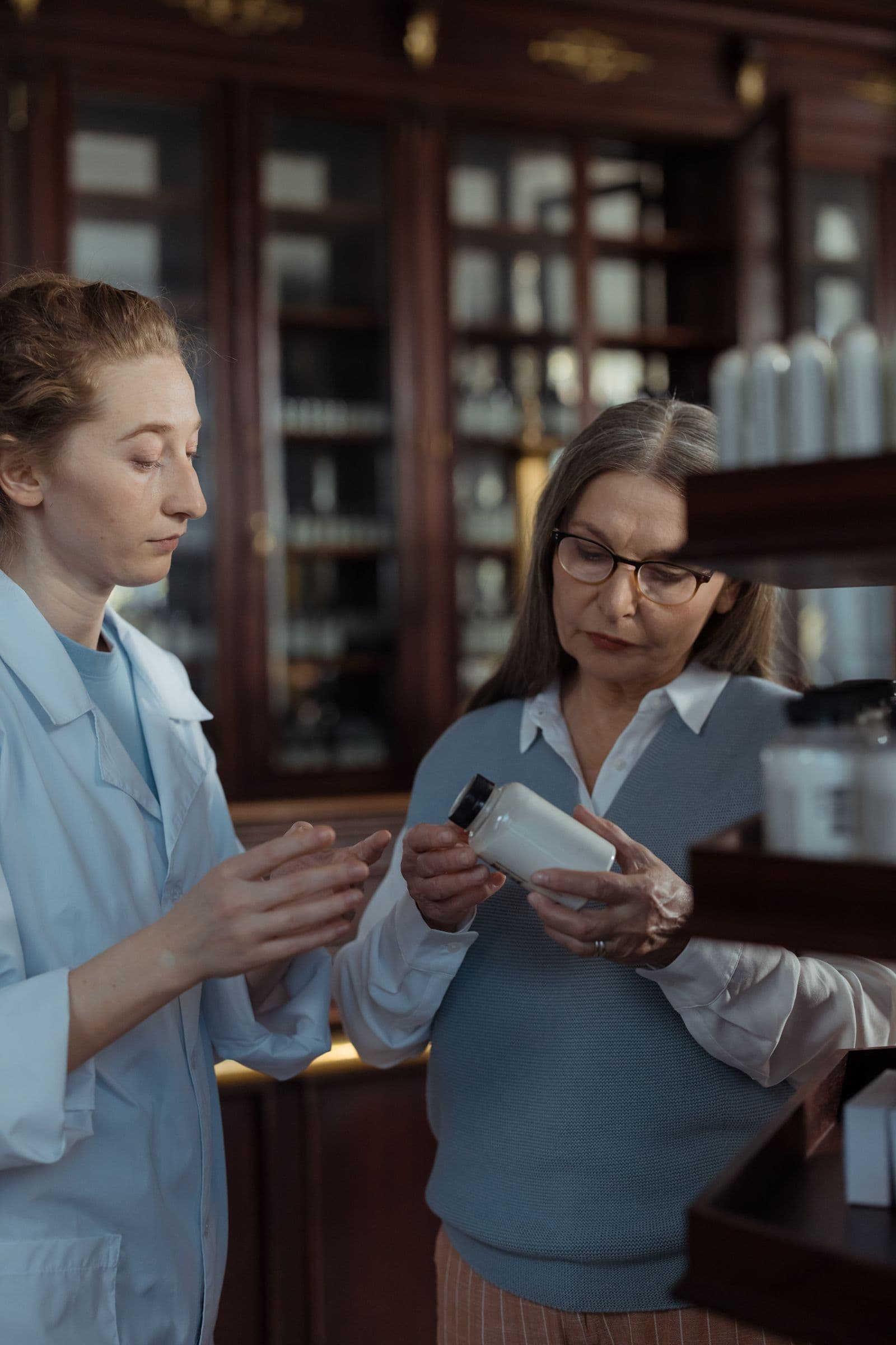 A customer and pharmacist discussing a medicine bottle