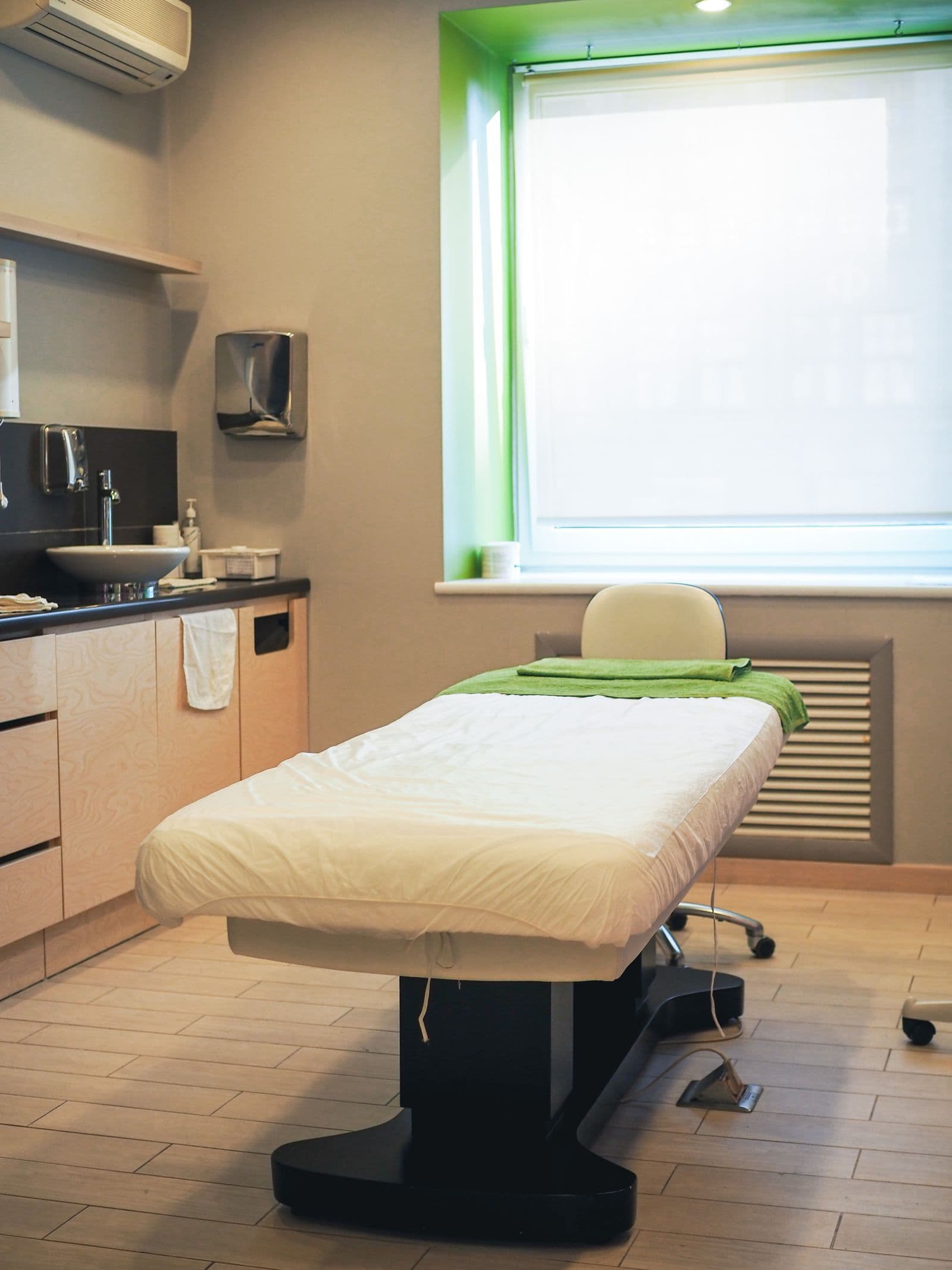 Empty medical examination room with a bed near a window