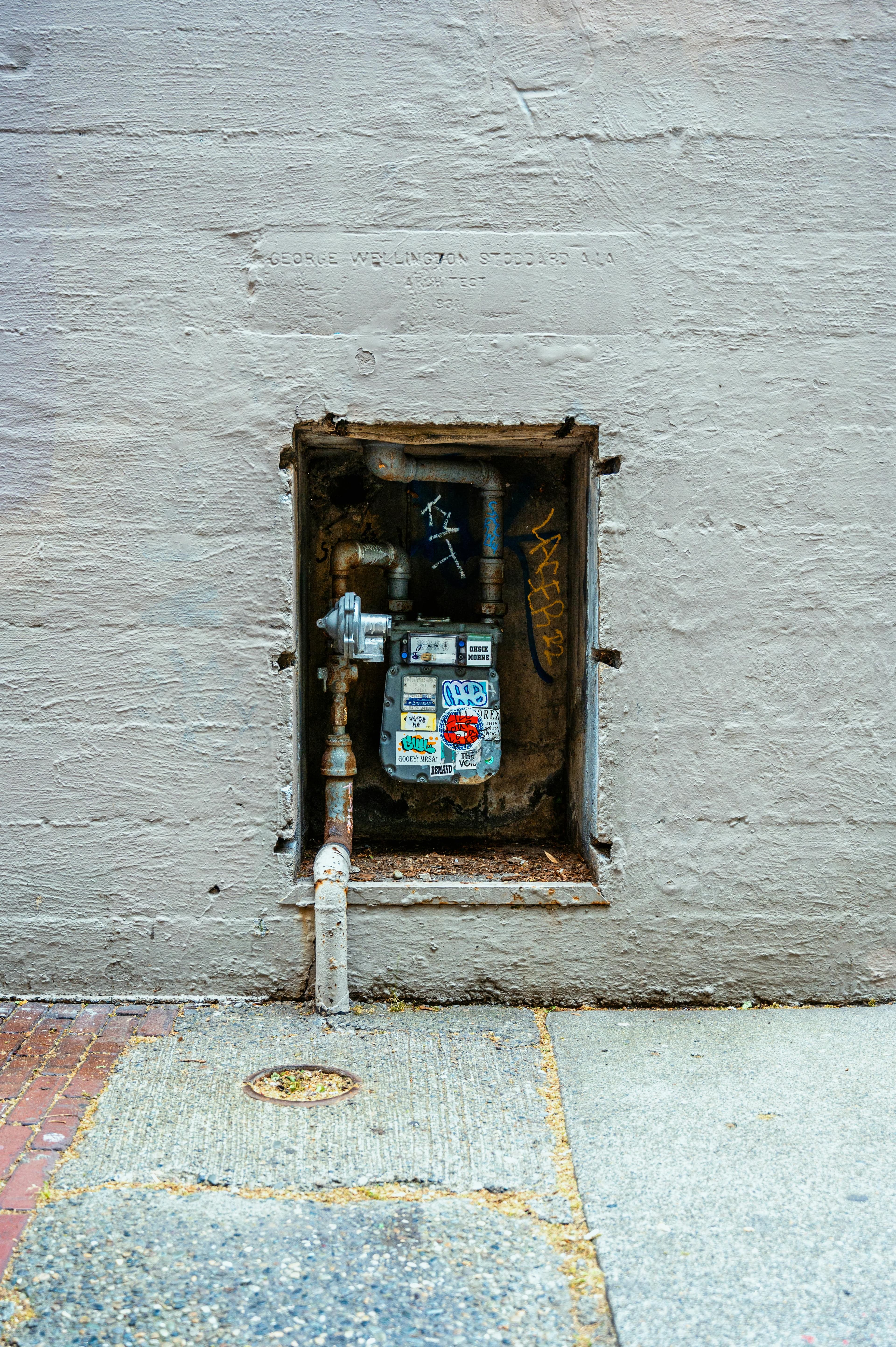 Utility meter box set into an exterior wall.