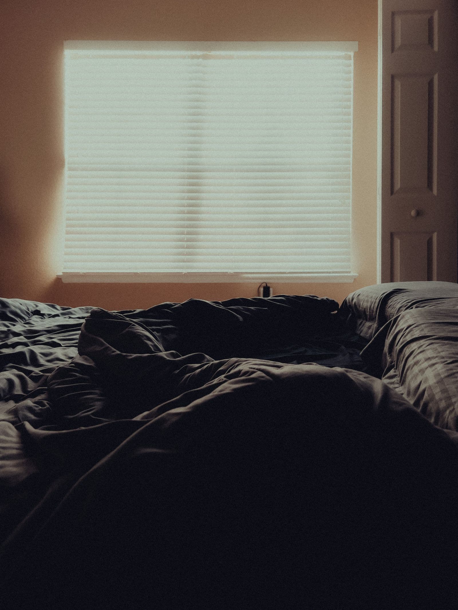 Unoccupied bed in a softly lit bedroom