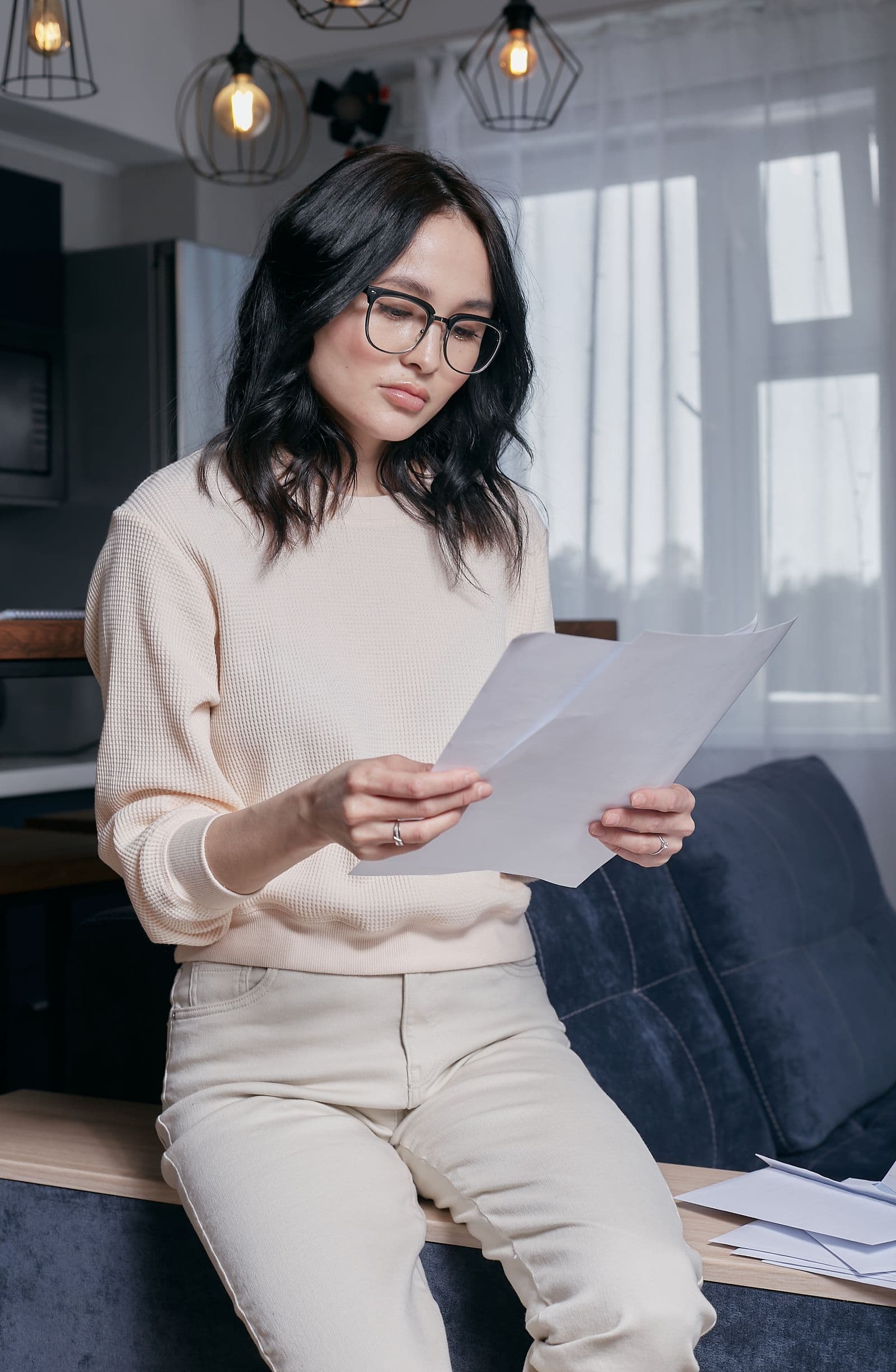 Woman reading household paperwork at home