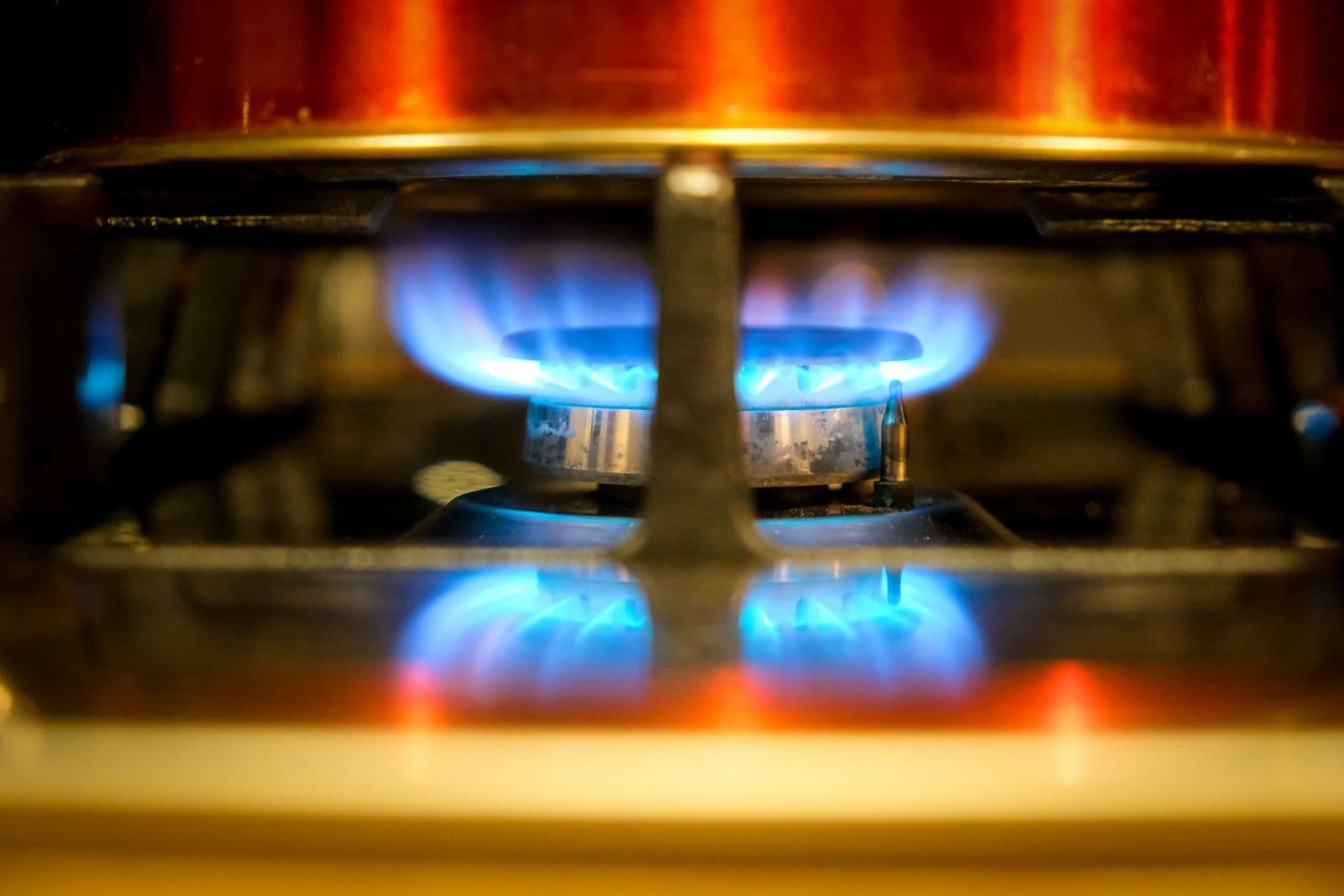 Blue flames burning around a household gas hob