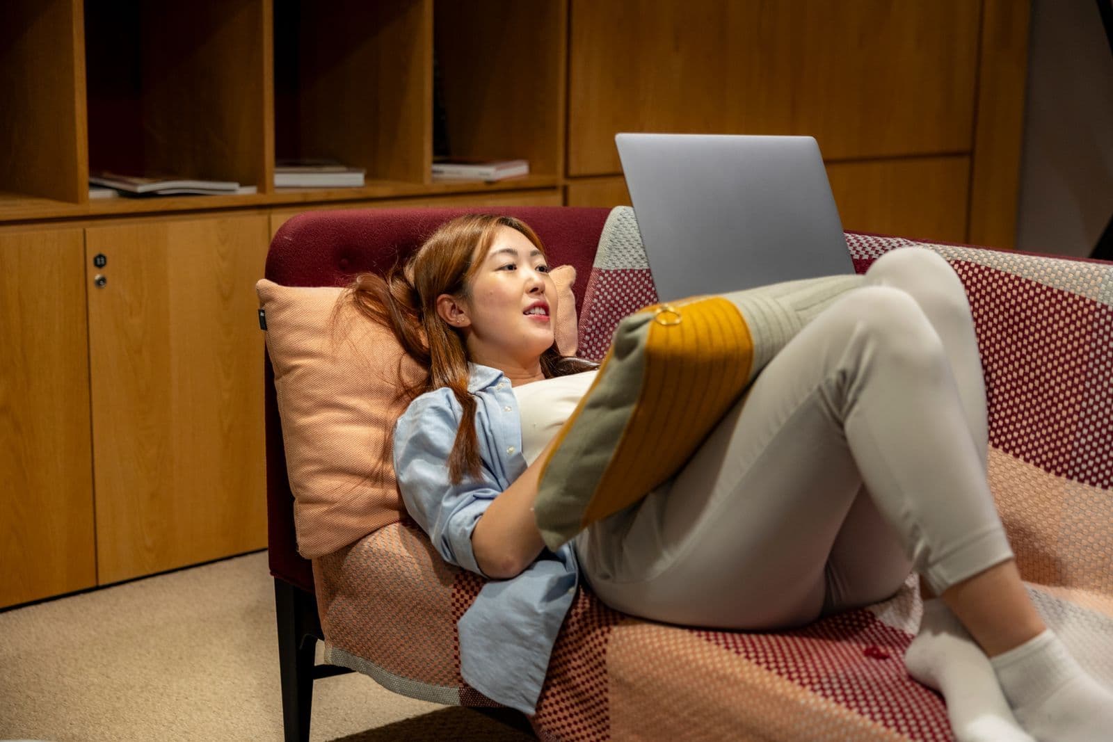 A person working on a laptop on a sofa