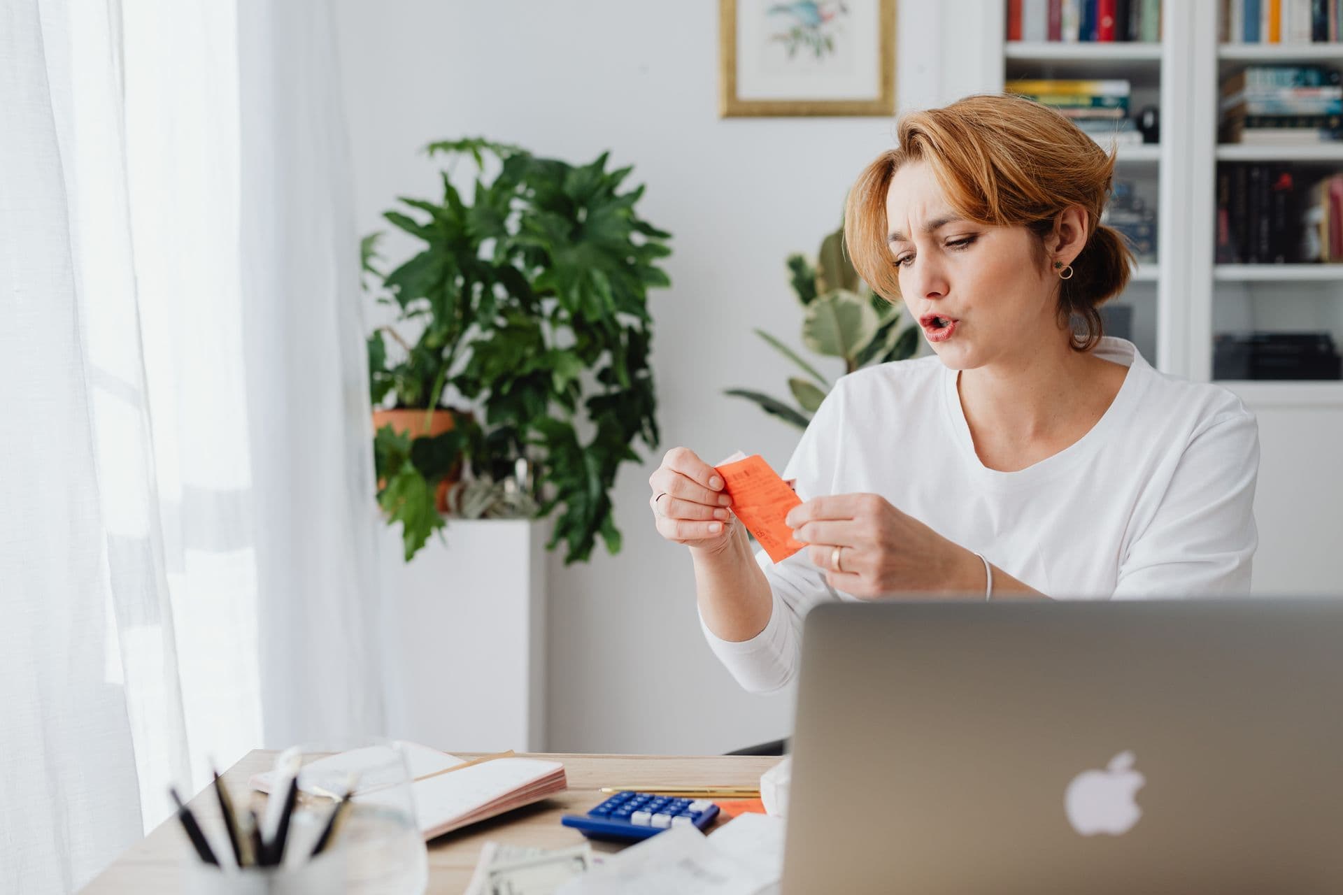 Woman reviewing household bills beside a laptop before an NBN discount ends