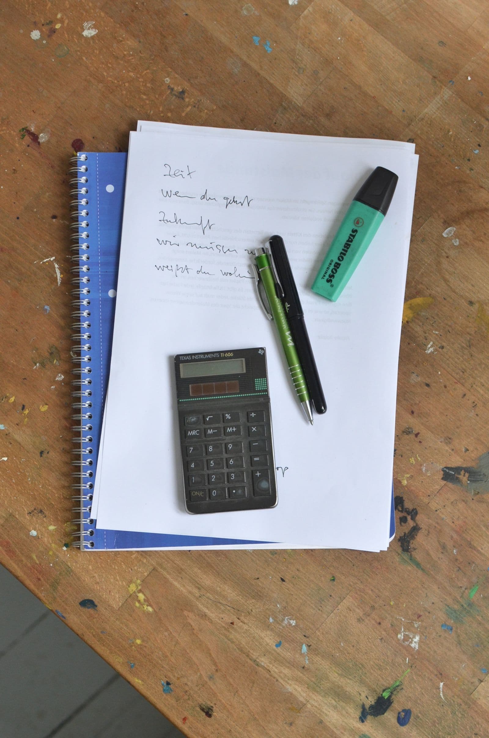 Calculator beside a notebook and stationery