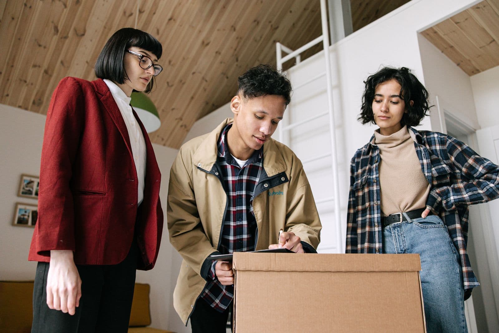 People looking at and signing paperwork beside moving boxes