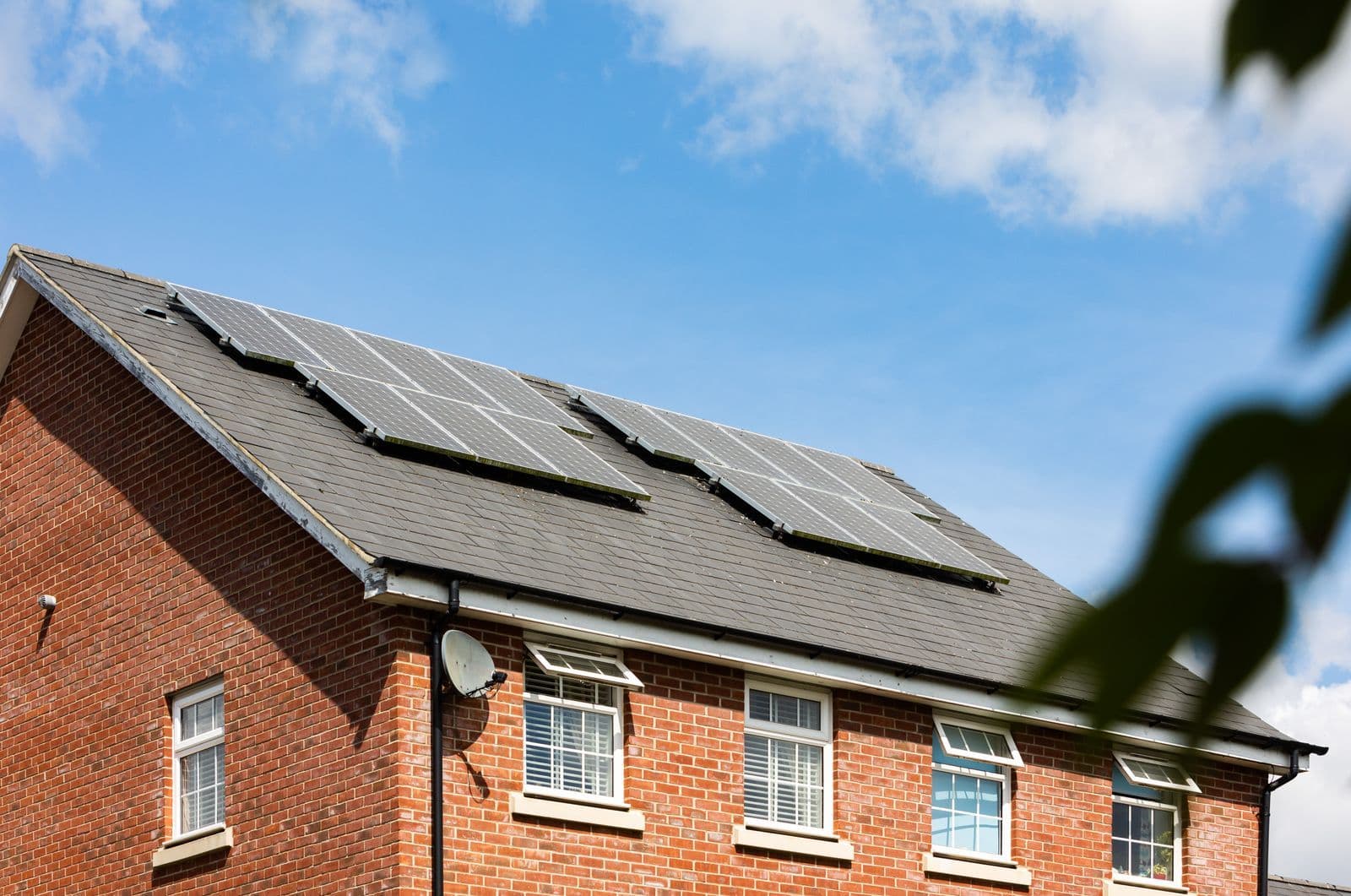 Solar panels on the roof of a brick residential building