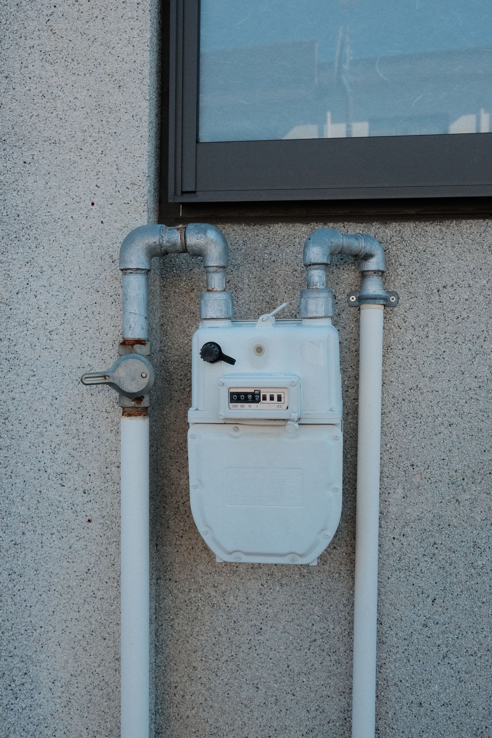 Exterior gas meter with connected pipes; illustrative installation