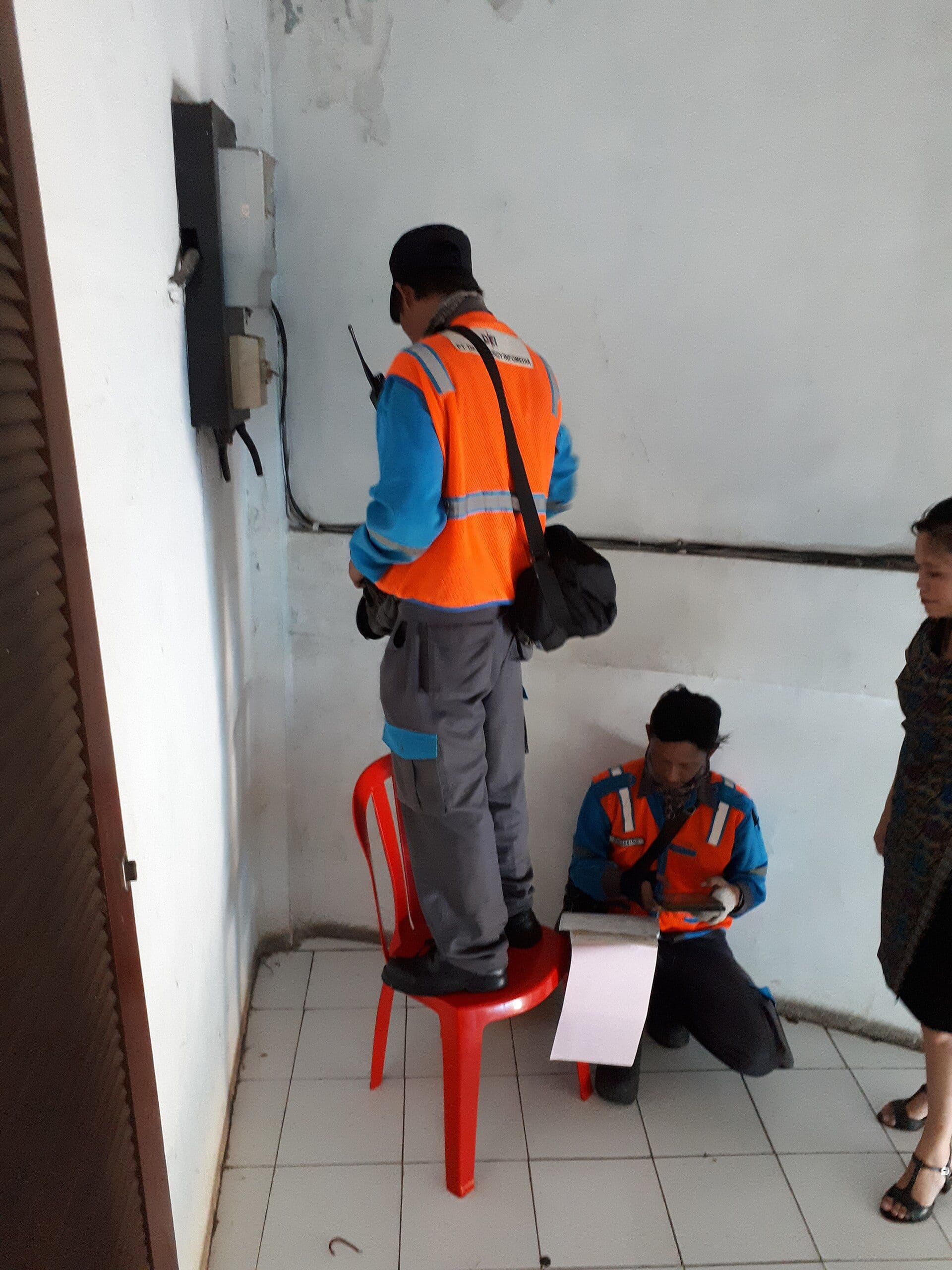Electricians working on an electricity meter for a household bill guide