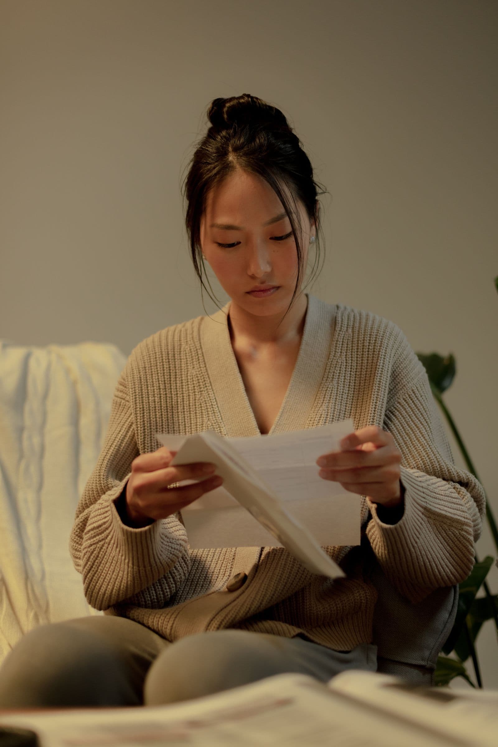 A woman reading a letter at home