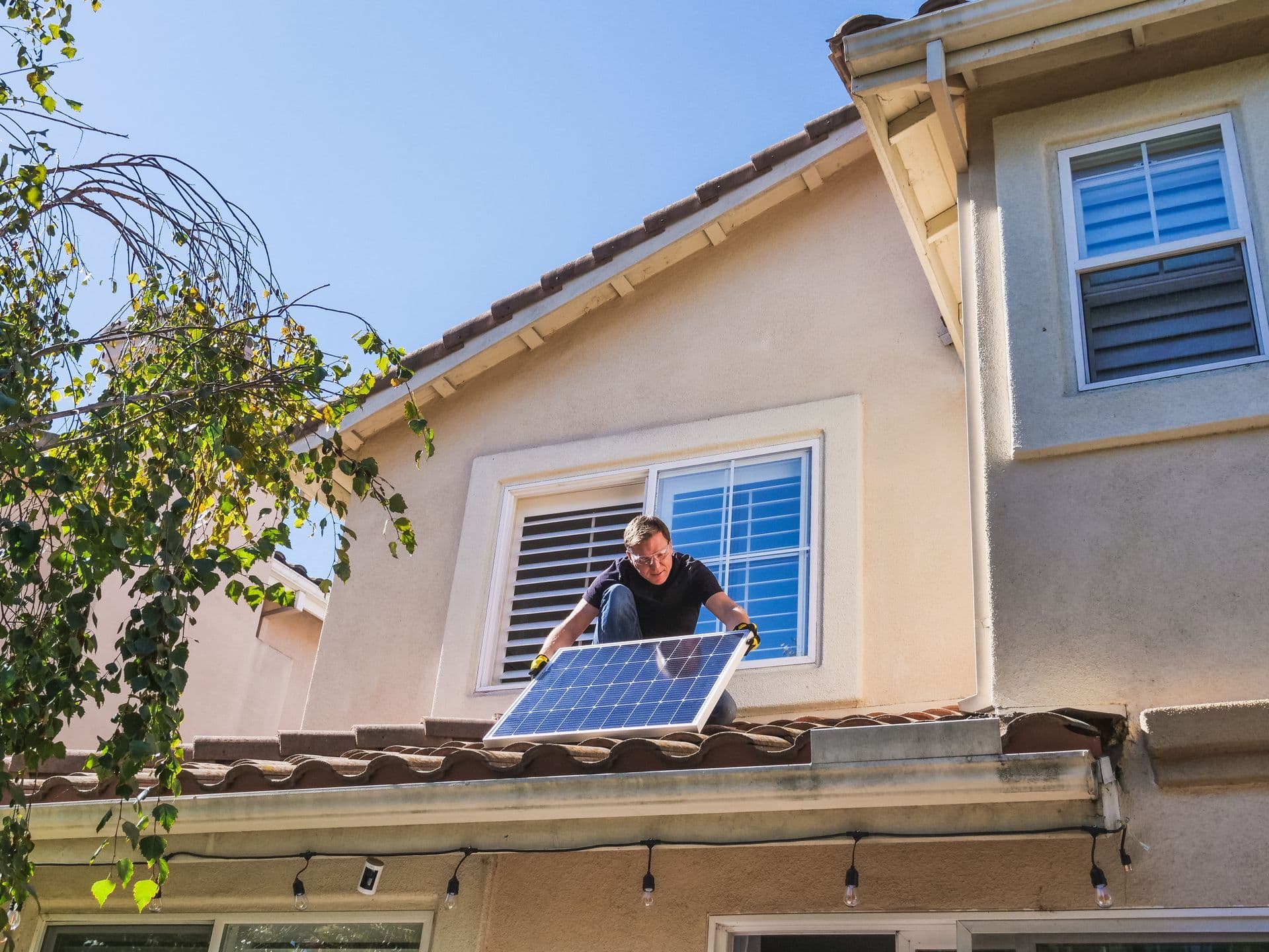 Accredited electrician inspecting rooftop solar panels on a house