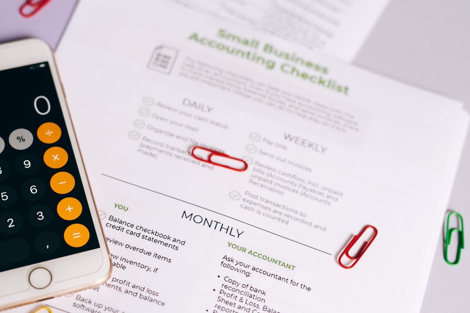A calculator on a phone beside business paperwork